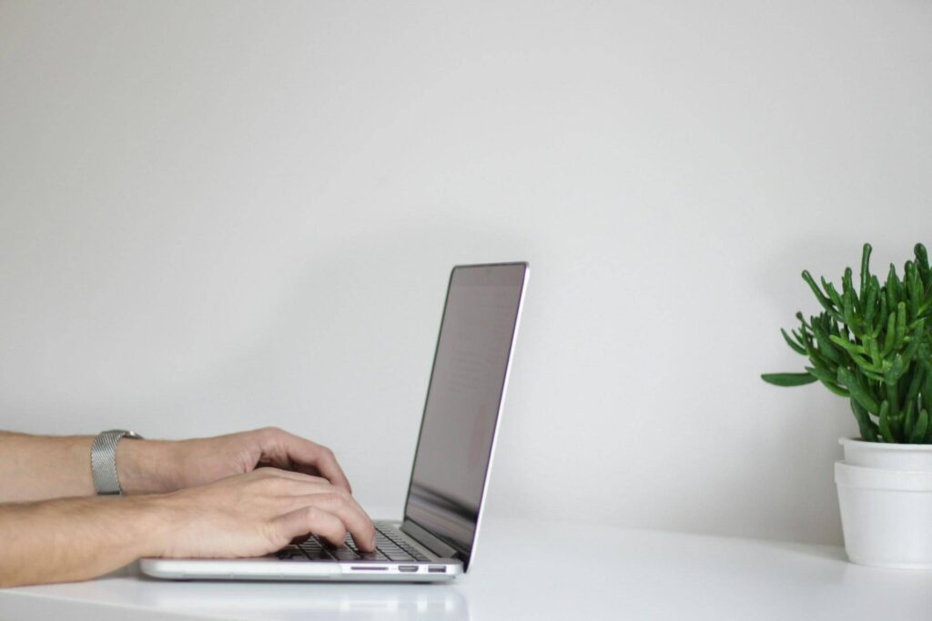 A man typing a letter on his laptop computer