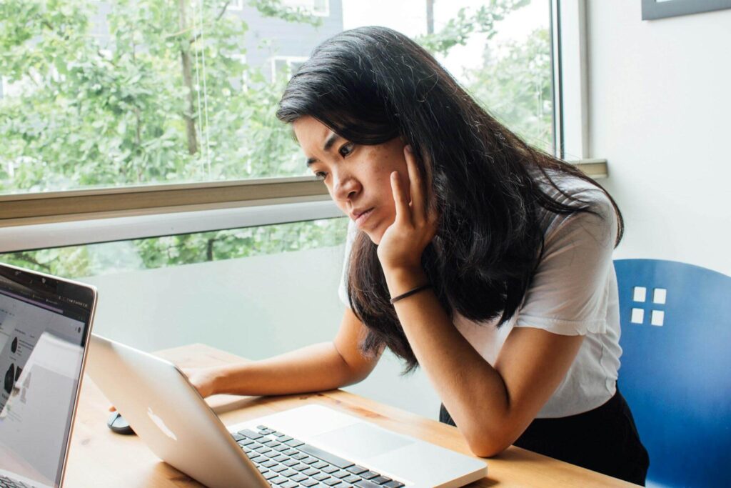 A student working out how to restate a thesis on a computer