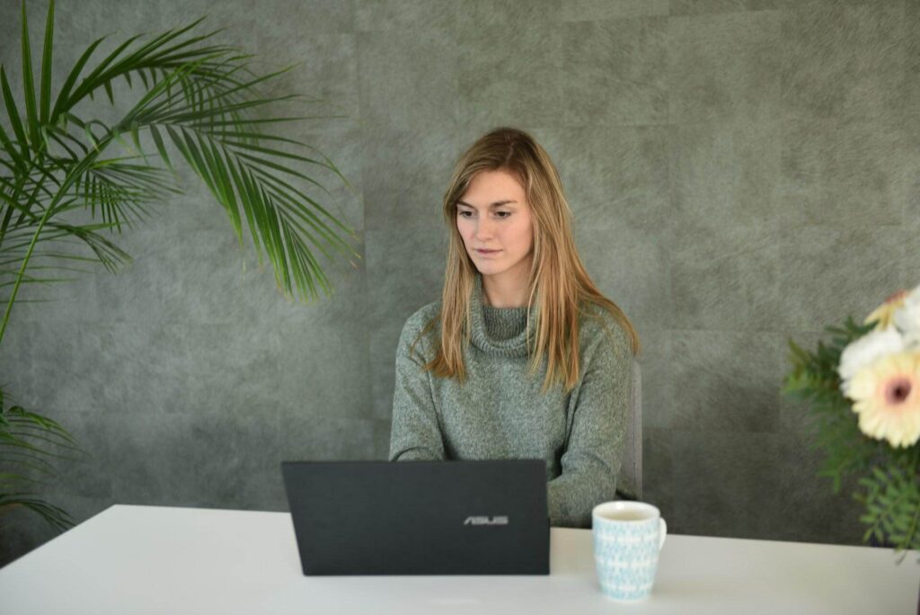 A woman writing on her laptop computer