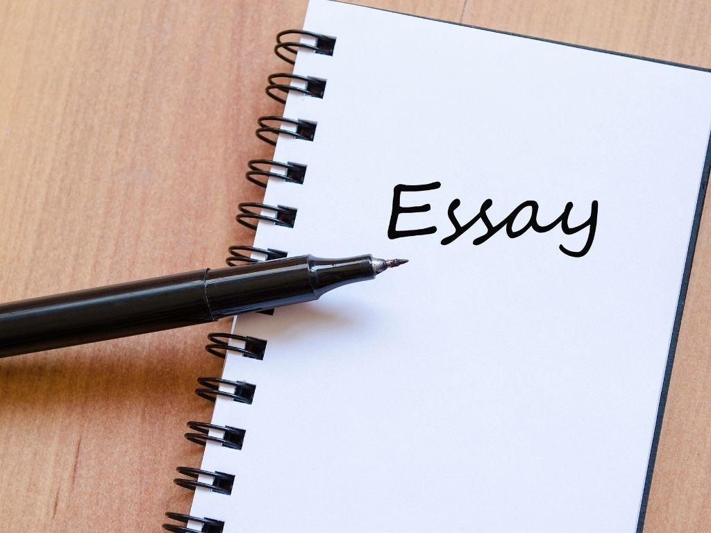 a notebook placed on a tabloe with the word "essay" written on it