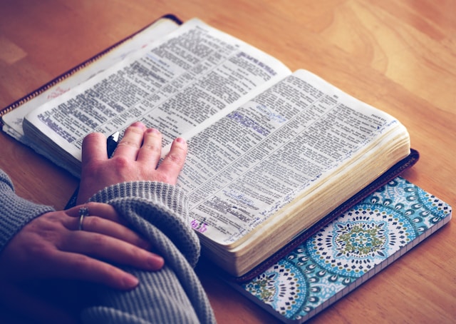 A person reading the Bible at a table