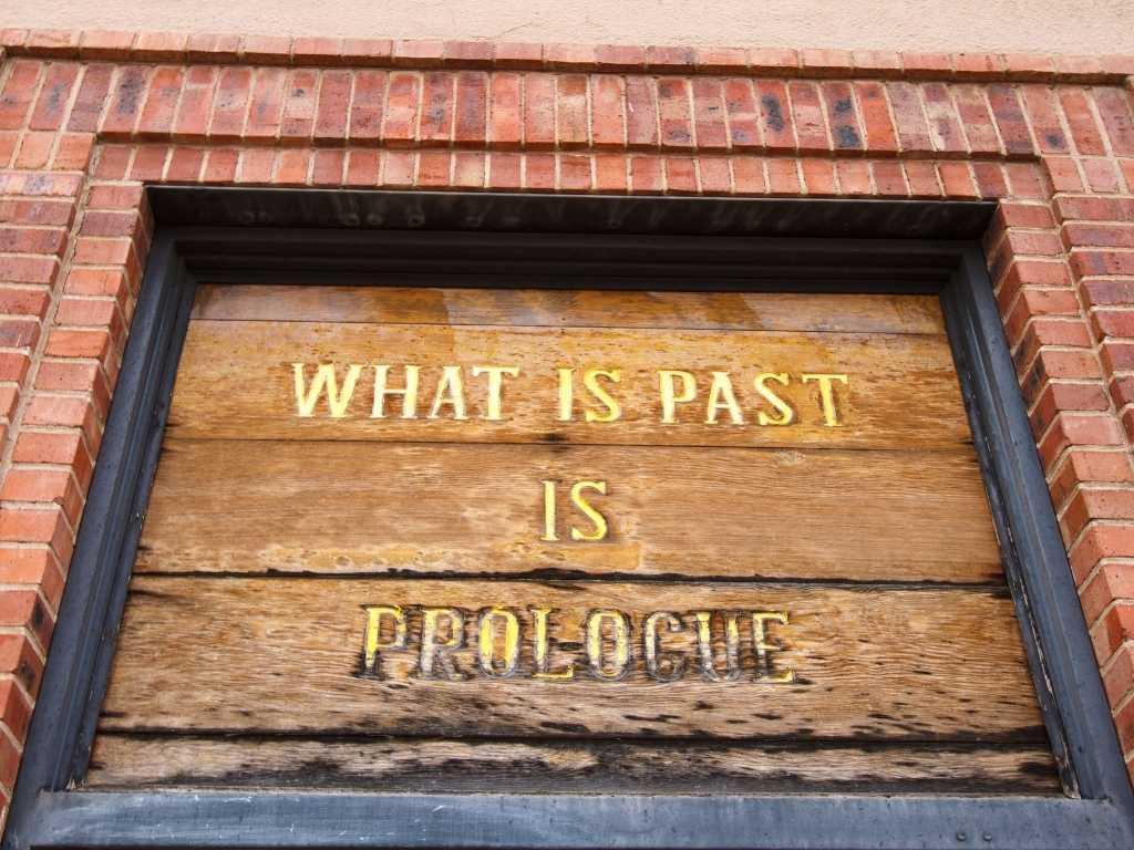 A door displaying a quote: "what is past is prologue."