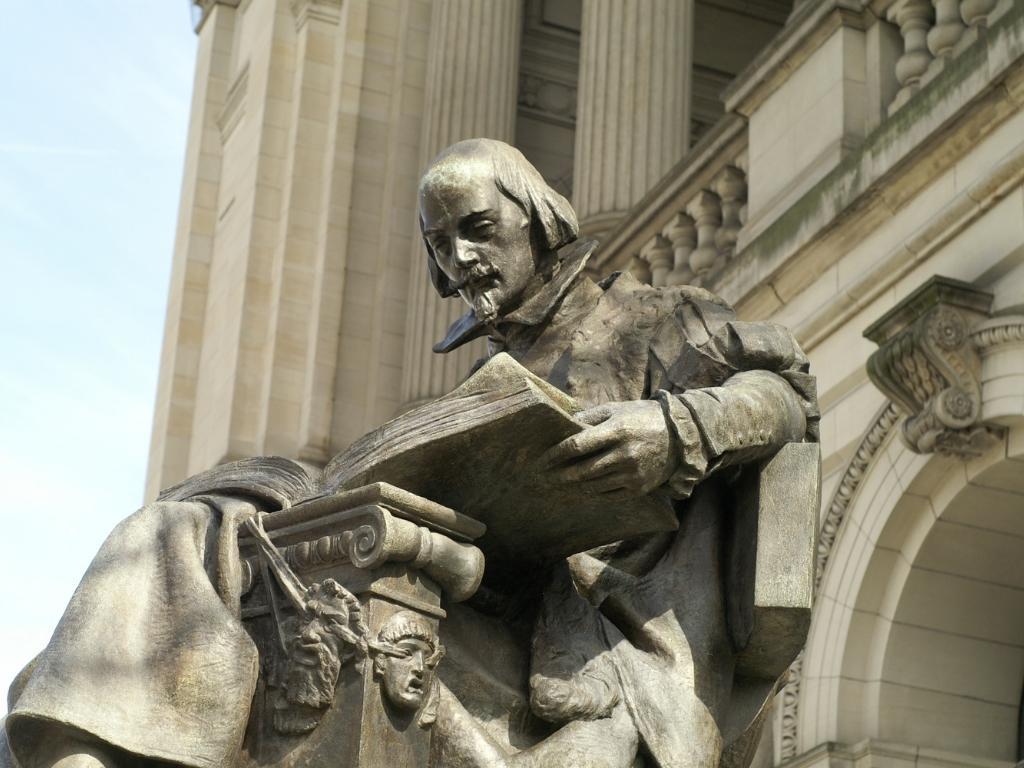 a statue of a poet reading a book.