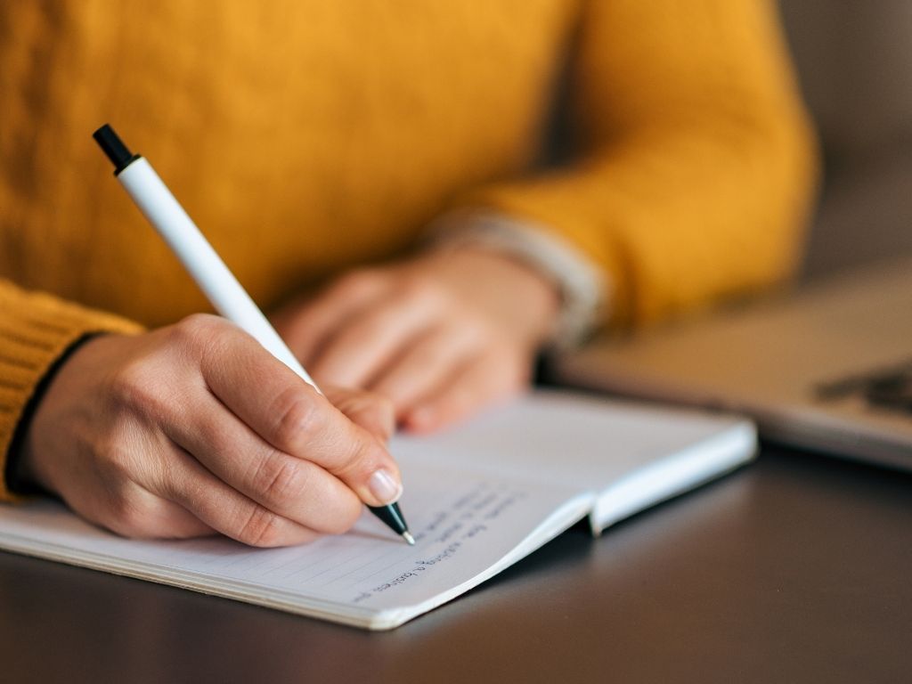 a girl writing on her notebook