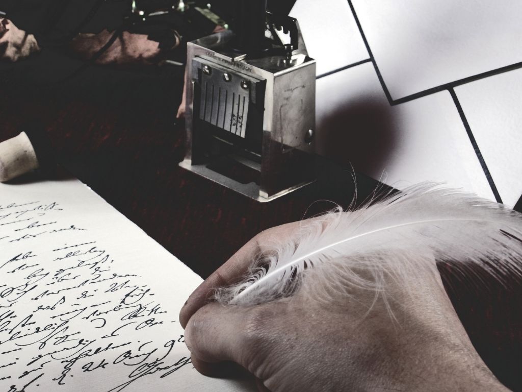 a person writing poetry with a leaf pen.