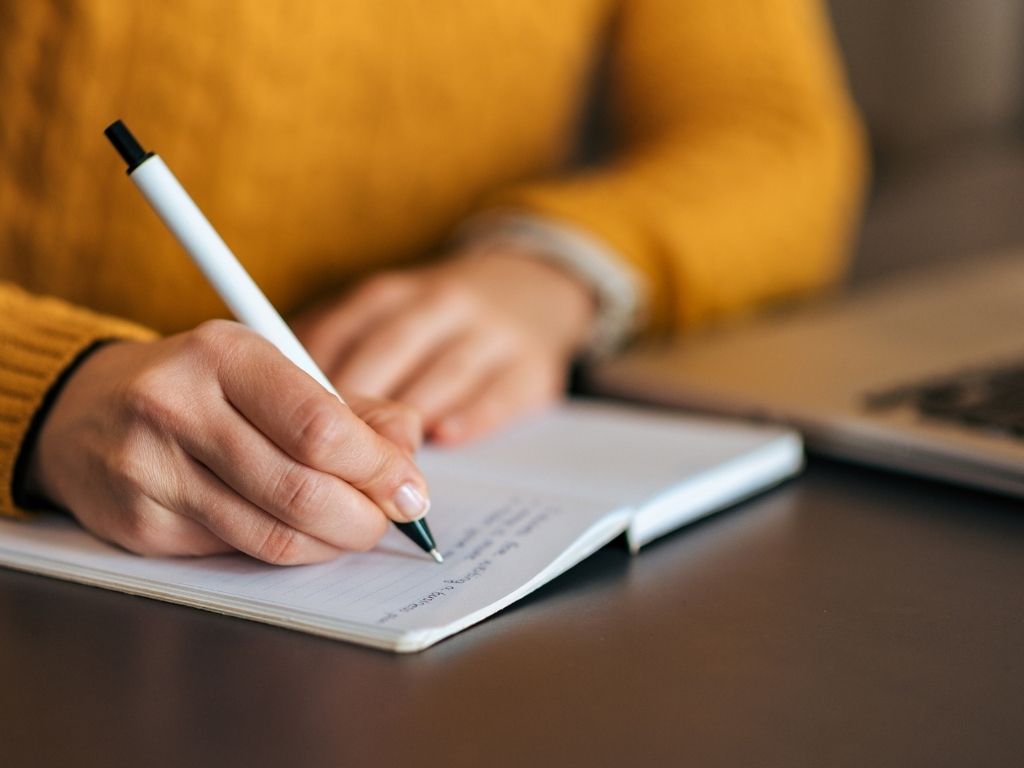 A student writing on her notebook. 