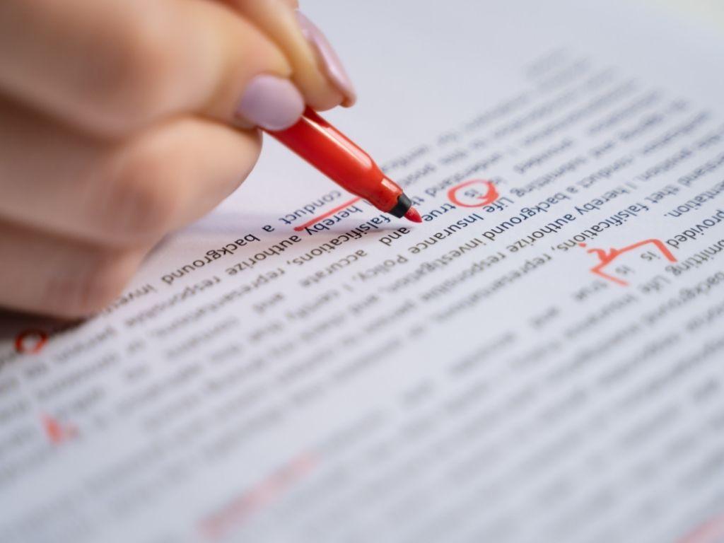 A girl highlighting some points with red marker on her book