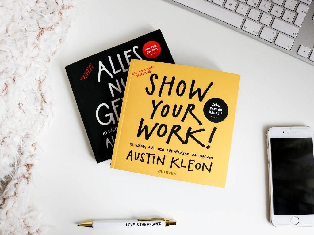 books placed on a counter with a pen and phone placed nearby