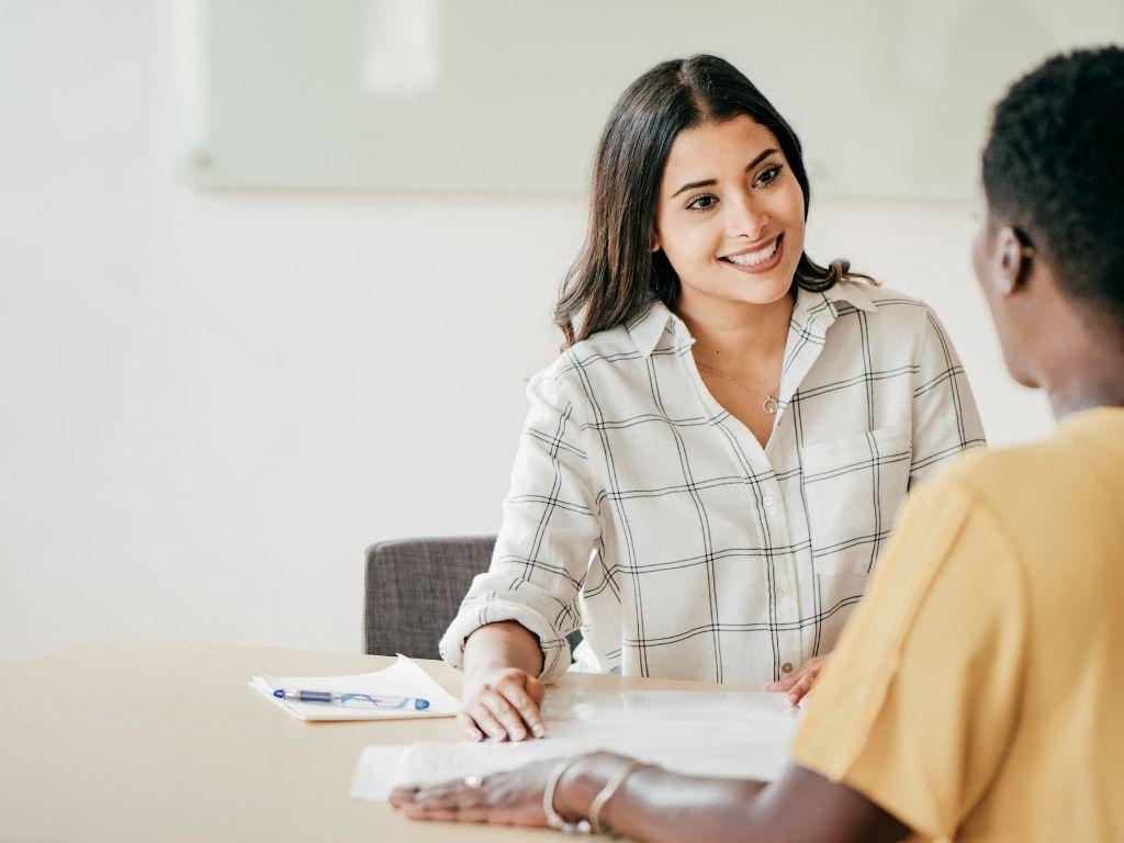 A girl conducting an interview with a man, smiling warmly as she engages in conversation about How to cite a personal Interview.