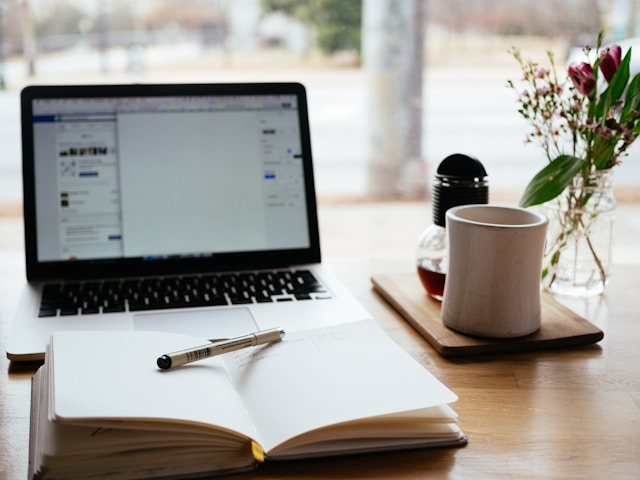 A computer, desk, and cup