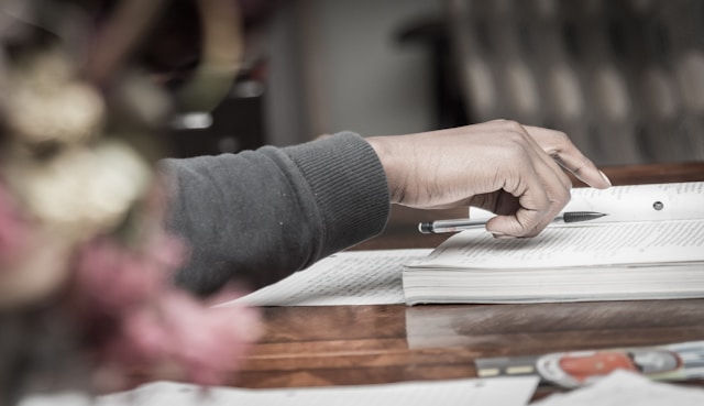 A student with a pen and book on the table