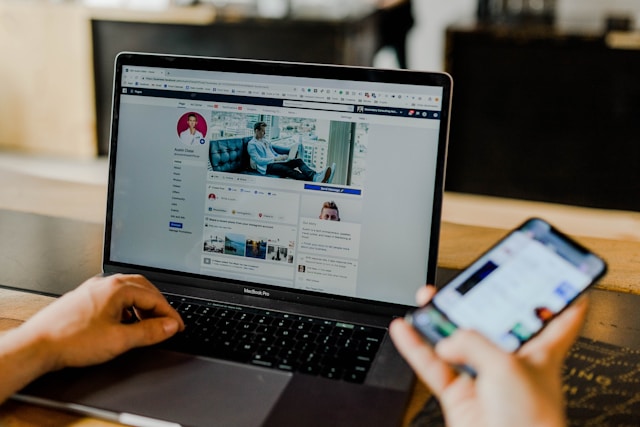 A person working on social media branding on a computer and phone