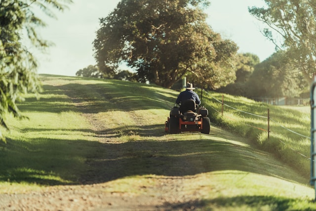 A man cutting his grass with a sit-on mower