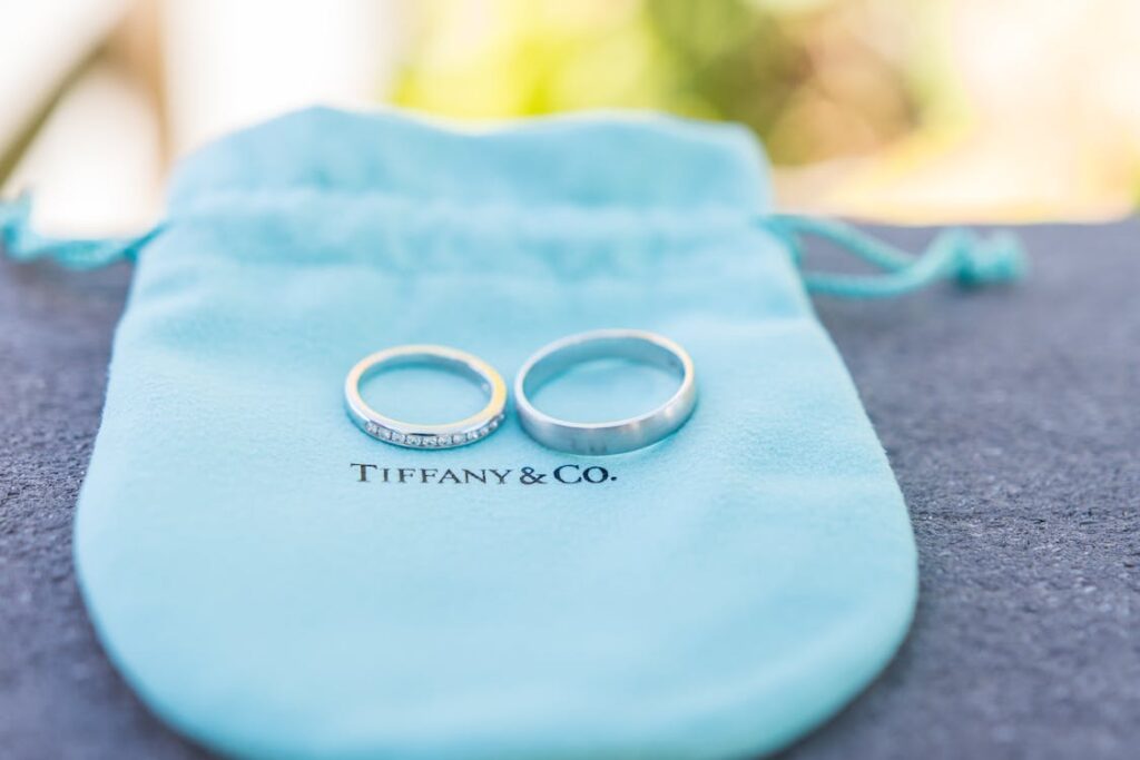 Free Two wedding rings on a Tiffany & Co. pouch, perfect for elegant jewelry presentations. Stock Photo