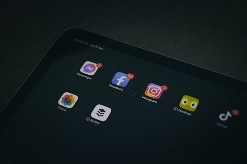 Free A tablet displaying popular apps like Facebook and Instagram in a dimly lit setting. Stock Photo