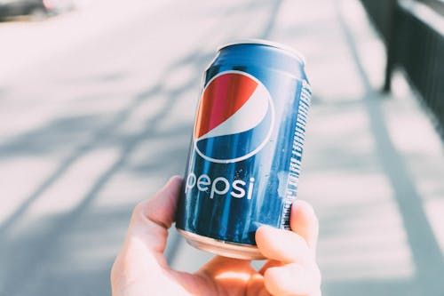 Free Refreshing Pepsi can held in hand on a sunny day. Perfect for advertisements. Stock Photo