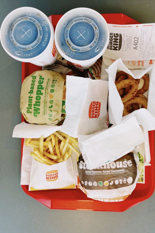 Free Tray of fast food with burgers, fries, and drinks served at Burger King in Hamburg, Germany. Stock Photo