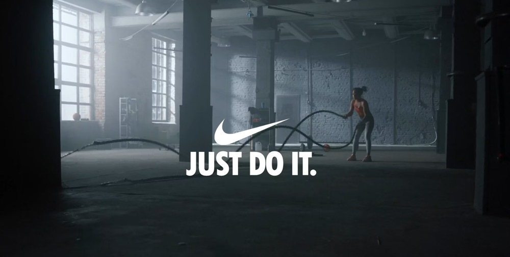 Just Do It Nike with a woman exercising in a warehouse